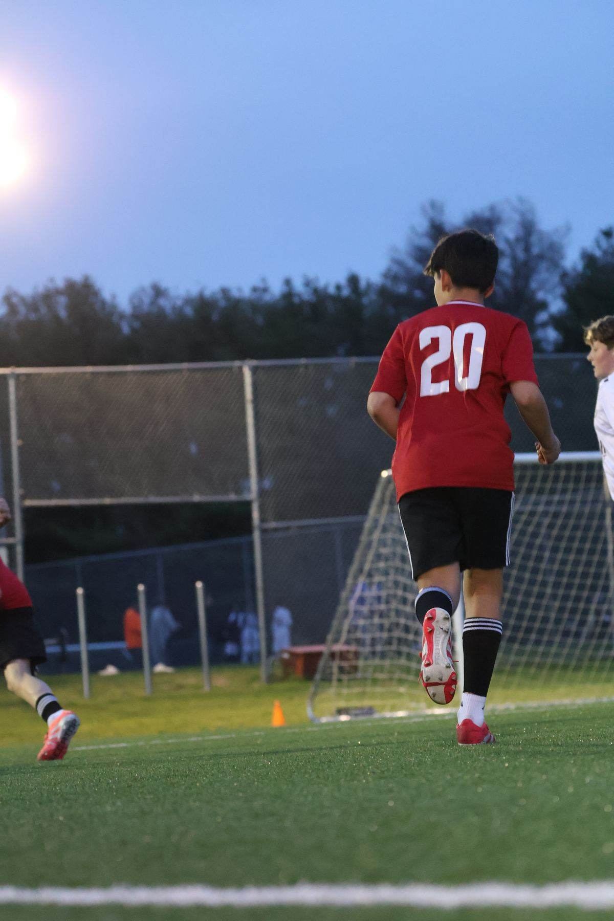Albertson player driving at goal under the lights